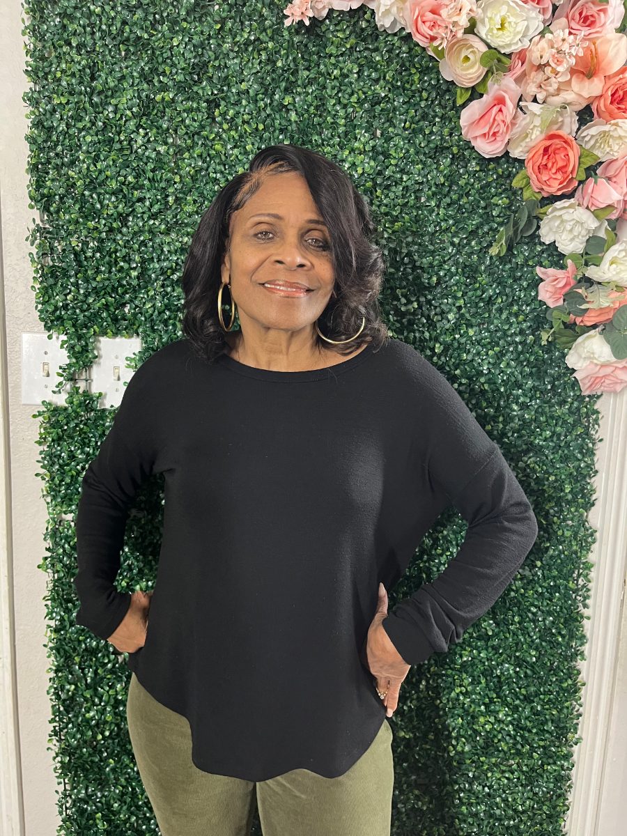 Patricia Woods, owner of Integrity Bookkeeping Service, smiling in front of a flower wall